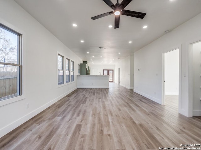 unfurnished living room featuring recessed lighting, healthy amount of natural light, a ceiling fan, light wood-style floors, and baseboards
