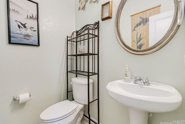 half bath with toilet and a sink