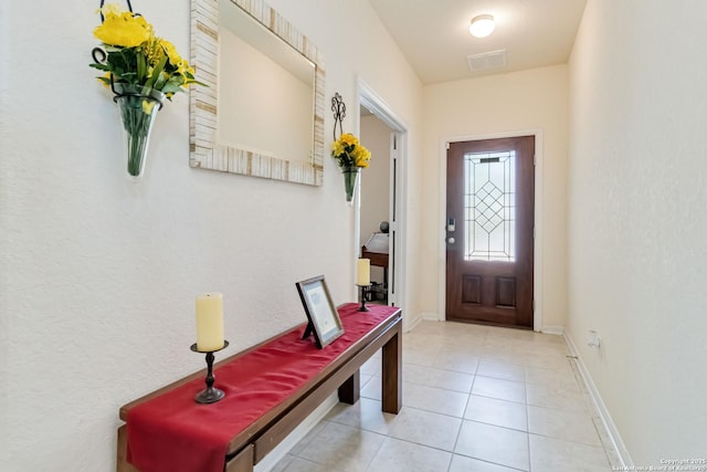 doorway with light tile patterned floors and baseboards