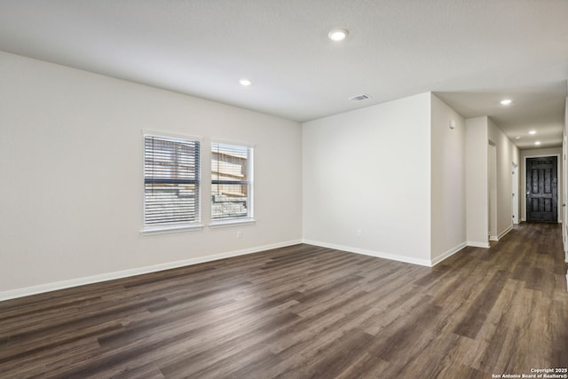 spare room featuring dark wood-style floors, recessed lighting, and baseboards