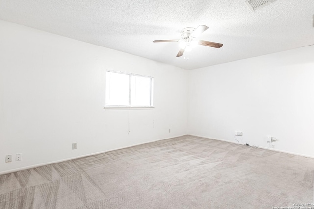carpeted spare room with a ceiling fan, a textured ceiling, and baseboards