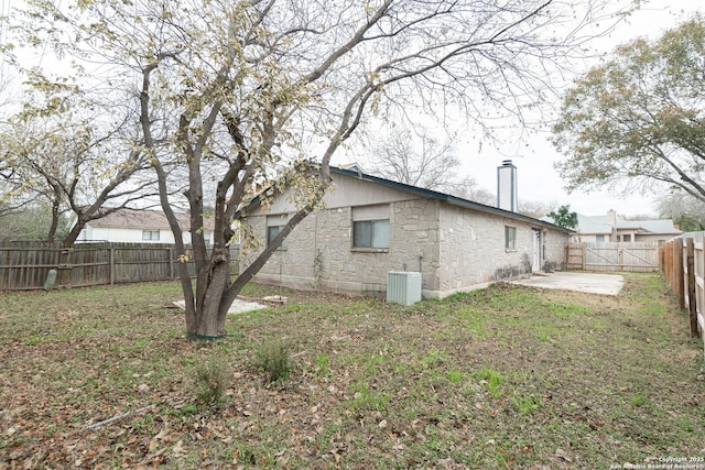 view of home's exterior with stone siding, a patio, and cooling unit