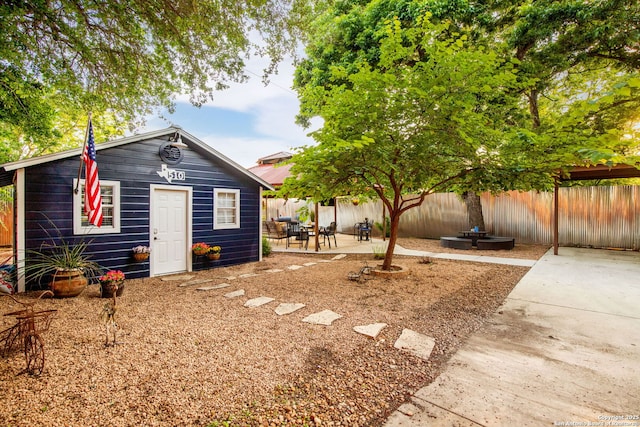 fenced backyard with a patio and an outdoor structure