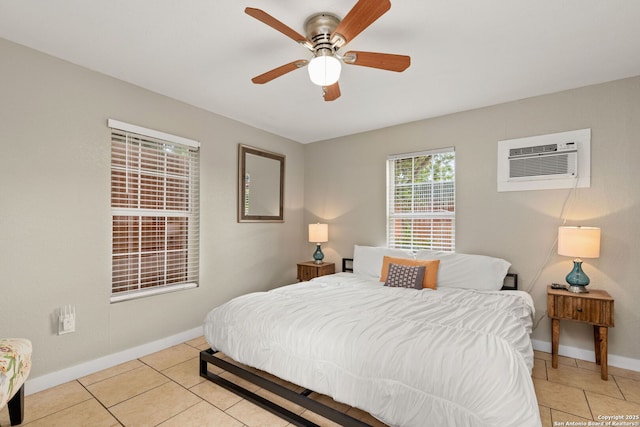 bedroom featuring a wall mounted AC, light tile patterned flooring, baseboards, and ceiling fan
