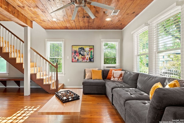 living room featuring healthy amount of natural light, stairs, hardwood / wood-style floors, wood ceiling, and ceiling fan