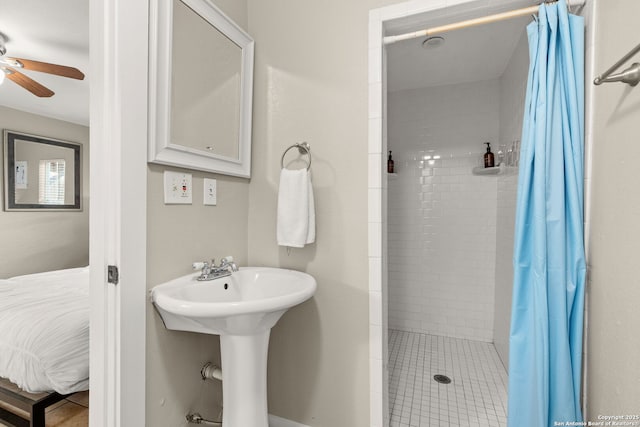 ensuite bathroom featuring a ceiling fan and a stall shower