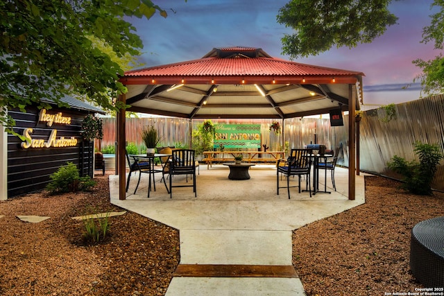 view of community with a gazebo, a fenced backyard, and a patio