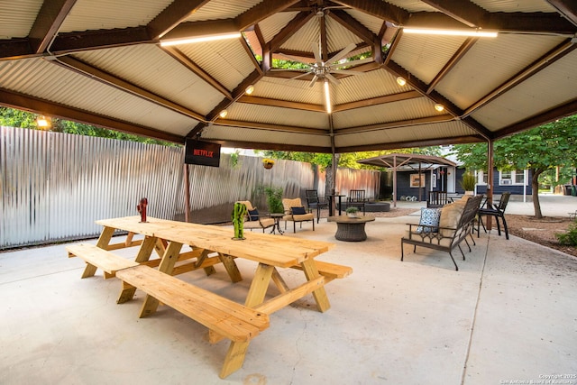 view of patio / terrace featuring a gazebo, a fenced backyard, outdoor dining space, and a fire pit