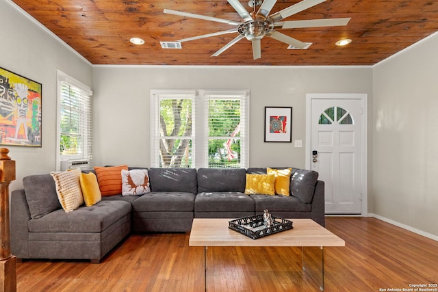 living room featuring wooden ceiling, healthy amount of natural light, ornamental molding, a ceiling fan, and wood finished floors