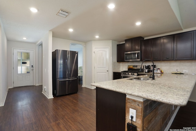 13340 Hackney Pony, San Antonio, TX 78254 - kitchen with appliances with stainless steel finishes, a sink, a peninsula, baseboards, and dark wood-style flooring