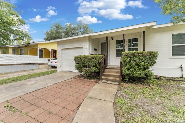 ranch-style home with concrete driveway, an attached garage, and fence