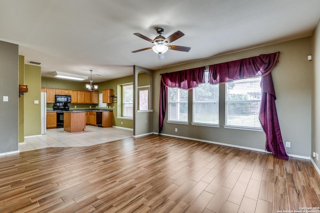9007 Burnt Peak, Helotes, TX 78023 - unfurnished living room featuring light wood-style floors, a chandelier, baseboards, and a ceiling fan