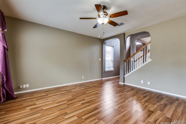 9007 Burnt Peak, Helotes, TX 78023 - spare room with arched walkways, light wood finished floors, ceiling fan, and baseboards