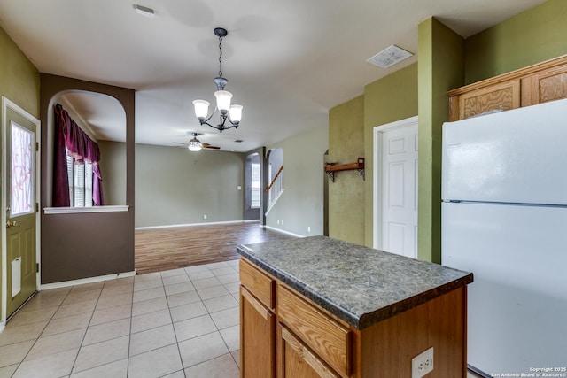 9007 Burnt Peak, Helotes, TX 78023 - kitchen featuring freestanding refrigerator, dark countertops, a chandelier, a ceiling fan, and arched walkways