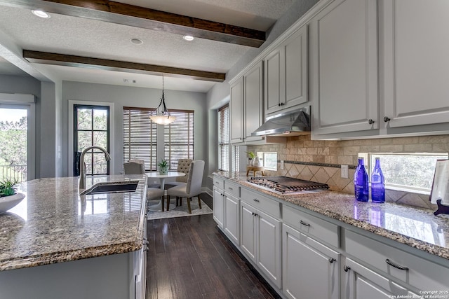 8826 Falcon Pl, San Antonio, TX 78256 - kitchen featuring a sink, stainless steel gas stovetop, under cabinet range hood, beam ceiling, and decorative backsplash