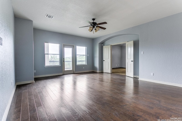 8826 Falcon Pl, San Antonio, TX 78256 - unfurnished room featuring arched walkways, a ceiling fan, dark wood finished floors, baseboards, and a textured wall
