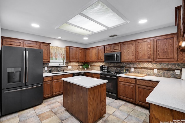 kitchen featuring black appliances, a sink, decorative backsplash, light countertops, and recessed lighting