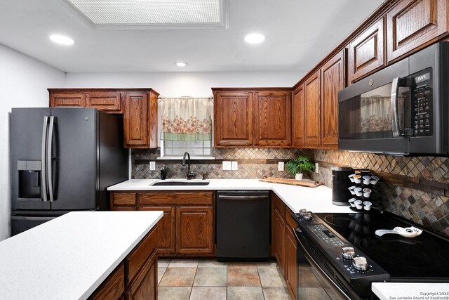 kitchen featuring black appliances, a sink, light countertops, tasteful backsplash, and recessed lighting