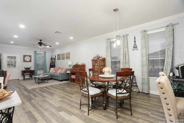 dining room featuring wood finished floors, ornamental molding, a ceiling fan, recessed lighting, and baseboards
