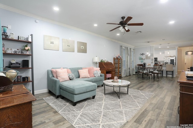 living area with crown molding, ceiling fan, light wood finished floors, recessed lighting, and baseboards
