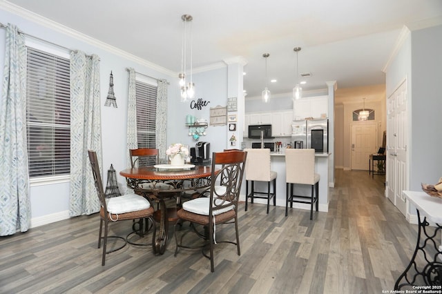 dining area with wood finished floors, ornamental molding, baseboards, and recessed lighting