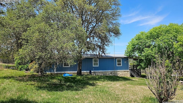 rear view of house with a lawn and stairs
