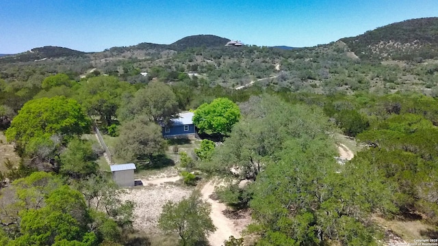 aerial view of property and surrounding area featuring mountains and a heavily wooded area