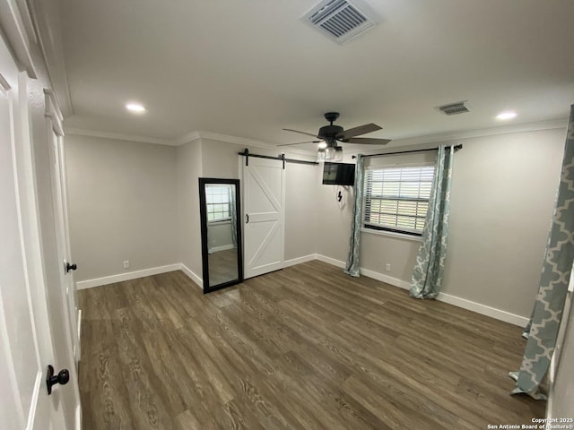 606 S Phelps St, Dilley, TX 78017 - spare room with a barn door, ornamental molding, plenty of natural light, baseboards, and dark wood finished floors
