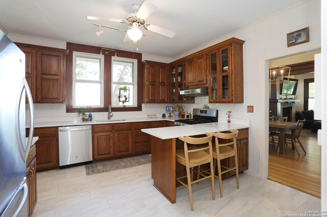 6160 Fm 2538, Marion, TX 78124 - kitchen with appliances with stainless steel finishes, a sink, a peninsula, under cabinet range hood, and decorative backsplash