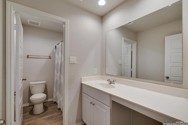 6039 Olson Blfs, San Antonio, TX 78252 - full bathroom with wood finished floors, toilet, vanity, and baseboards