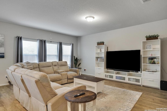 6039 Olson Blfs, San Antonio, TX 78252 - living area featuring light wood finished floors, a textured ceiling, and baseboards