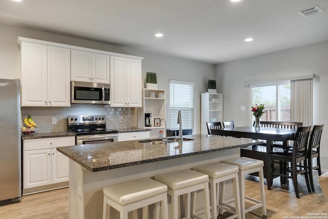 6039 Olson Blfs, San Antonio, TX 78252 - kitchen featuring stainless steel appliances, a sink, light wood finished floors, white cabinets, and recessed lighting