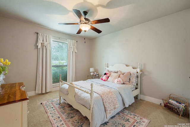 bedroom with light colored carpet, a ceiling fan, and baseboards