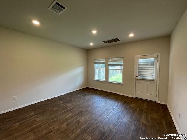 unfurnished room with dark wood finished floors, baseboards, and recessed lighting