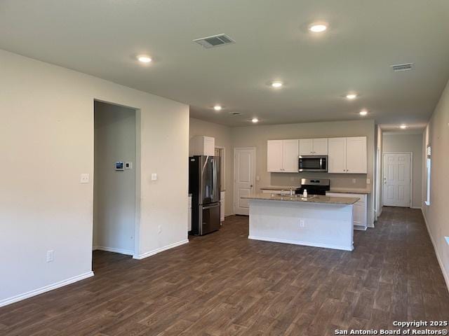 kitchen with appliances with stainless steel finishes, dark wood finished floors, baseboards, white cabinetry, and recessed lighting