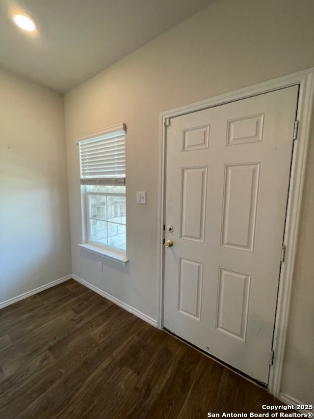 entrance foyer with dark wood-type flooring and baseboards