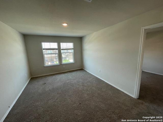 carpeted empty room with baseboards