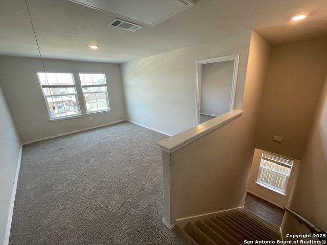 carpeted spare room with attic access, baseboards, and recessed lighting