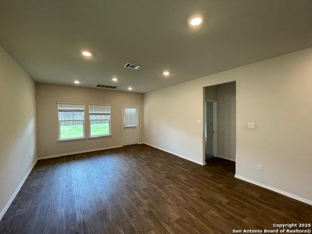 spare room with baseboards, dark wood-style floors, and recessed lighting