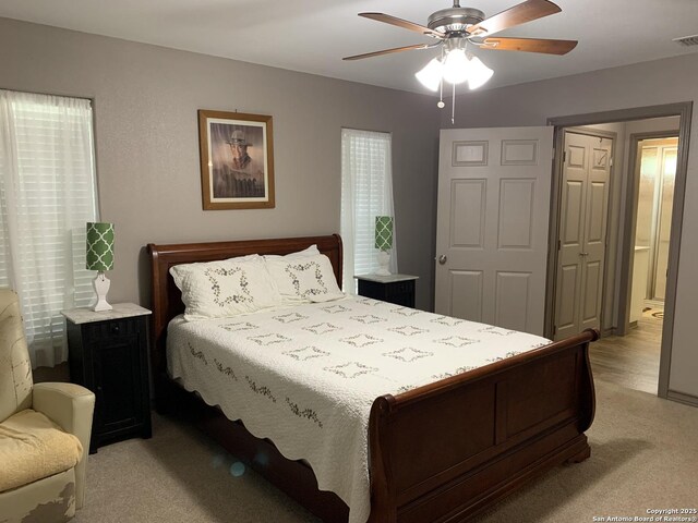 bedroom with light carpet and a ceiling fan