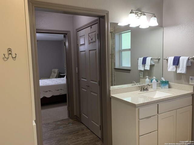 ensuite bathroom with wood finished floors and vanity