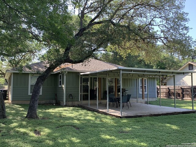 back of house with board and batten siding and a deck