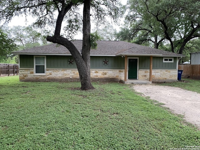 view of front of home with stone siding, a shingled roof, and board and batten siding