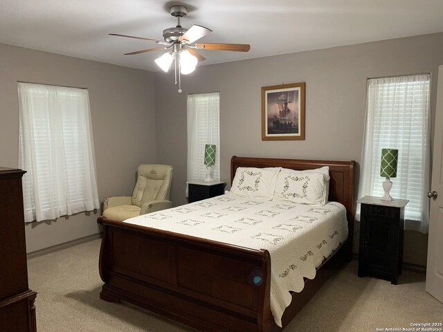 bedroom featuring light carpet and a ceiling fan