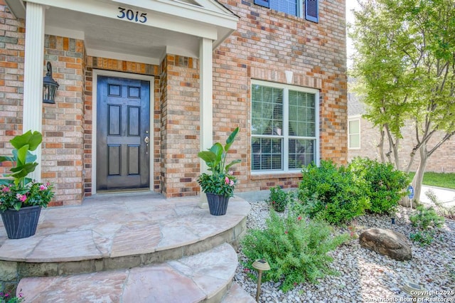 entrance to property featuring brick siding