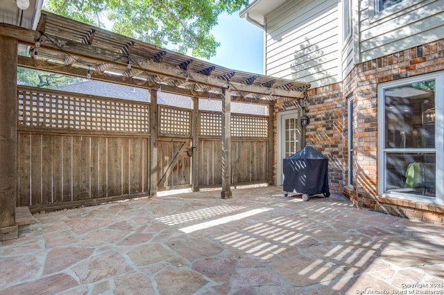 view of patio with a pergola, fence, grilling area, and a gate
