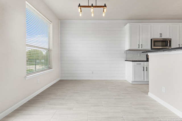 3727 Columbia, Cibolo, TX 78108 - kitchen with stainless steel microwave, baseboards, dark countertops, and white cabinetry