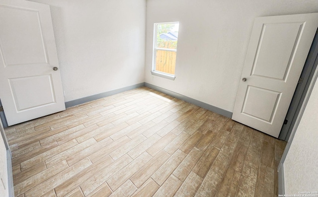 spare room with wood finished floors and baseboards