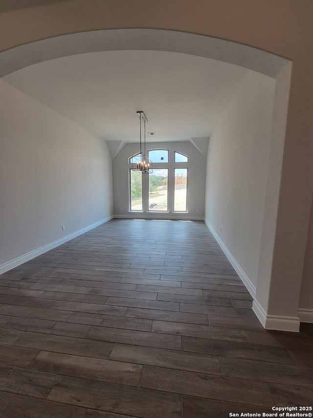 14074 May Mist, San Antonio, TX 78253 - unfurnished dining area with lofted ceiling, a chandelier, dark wood-style floors, arched walkways, and baseboards