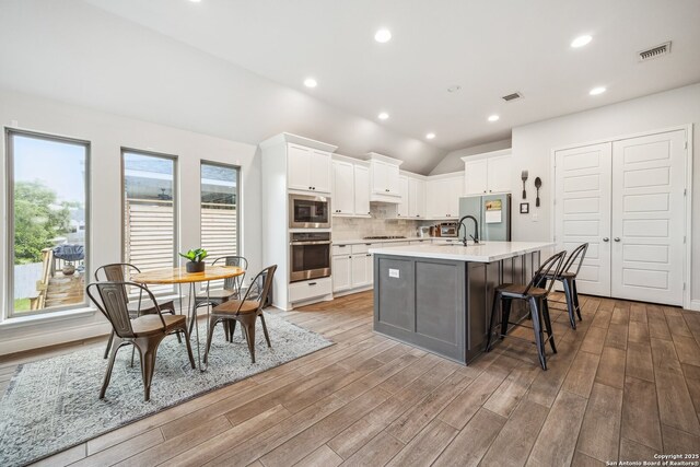14074 May Mist, San Antonio, TX 78253 - kitchen with appliances with stainless steel finishes, light wood-style flooring, white cabinets, light countertops, and vaulted ceiling